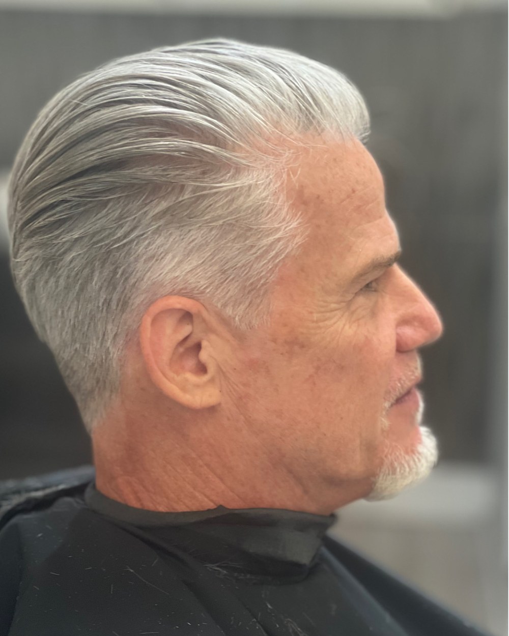 Men's haircut with silver swept back styling
